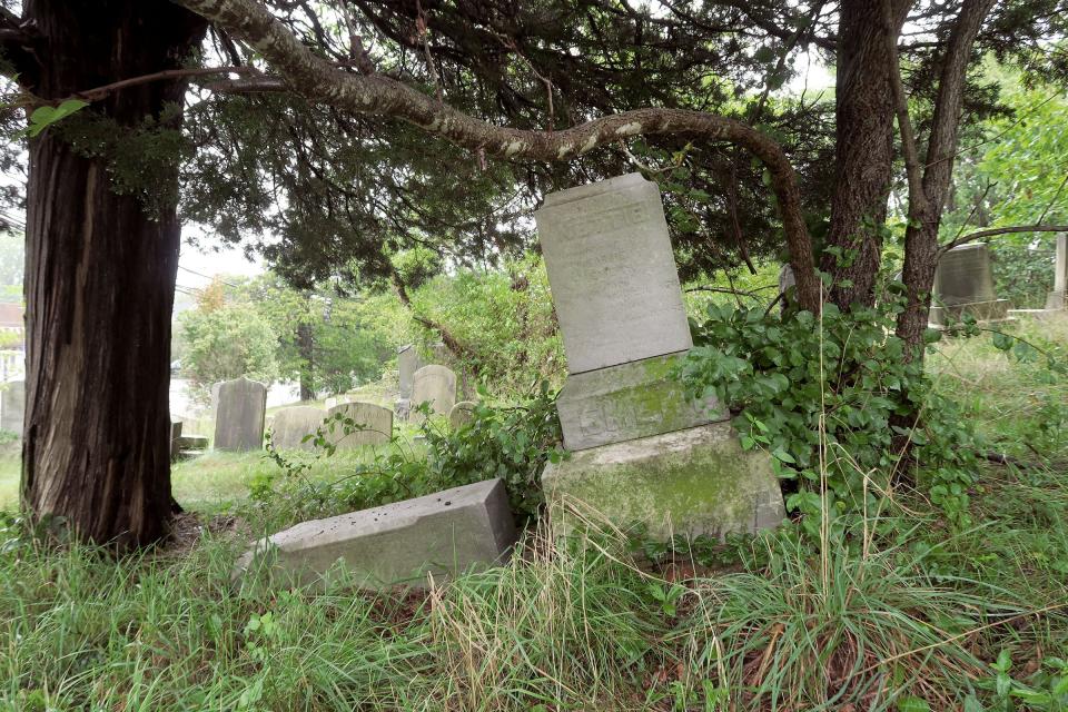 Tree roots are tipping a headstone down a hill in the cemetery surrounding the Old Methodist Church on Locust Avenue in West Long Branch Monday, September 18, 2023. While the cemetery next to the Old Methodist Church in West Long Branch is still cared for, two adjoining cemeteries are not.