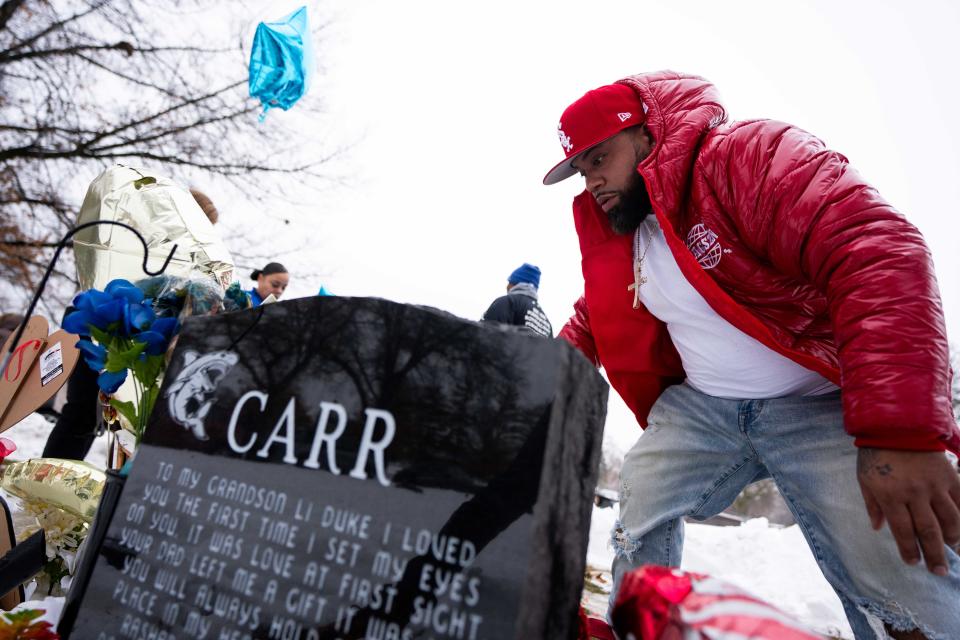 Gary Dameron, Gionni Dameron's father, prepares his son's gravesite, which is next to Rashad Carr's, on the anniversary of the Starts Right Here shooting Tuesday, Jan. 23, 2024, at Glendale Cemetery in Des Moines.