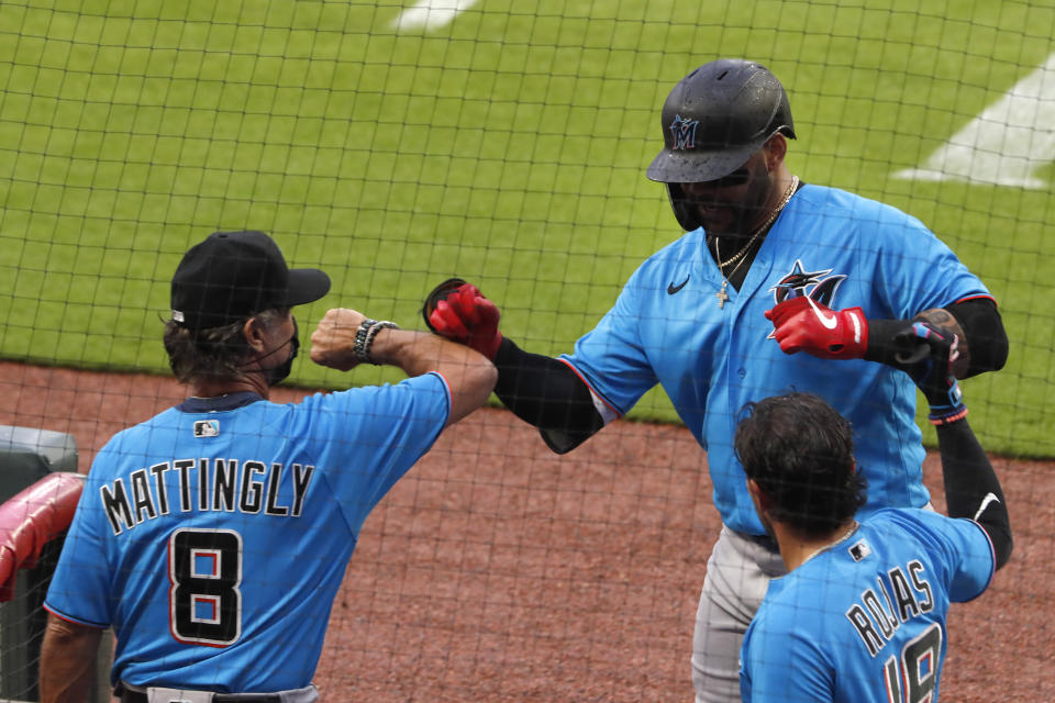 Miami Marlins' Jonathan Villar (2), center, is greeted a the dugout by Miami Marlins manager Don Mattingly (8) after hitting a home run in the third inning of an exhibition baseball game against the Atlanta Braves Tuesday, July 21, 2020, in Atlanta. (AP Photo/John Bazemore)