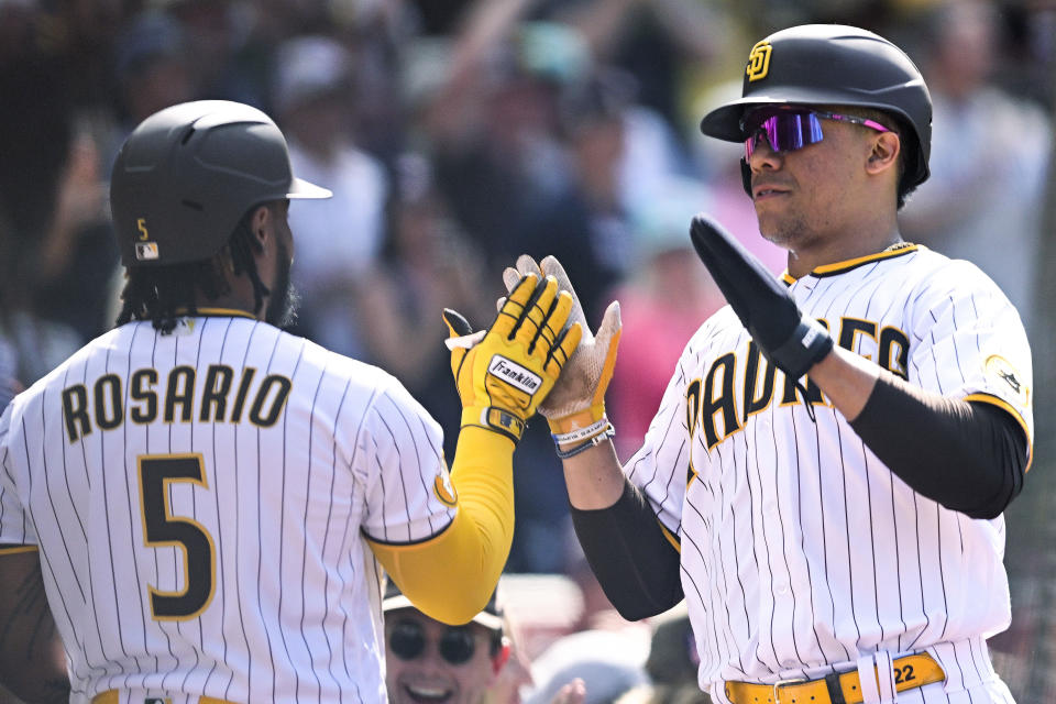 San Diego Padres' Juan Soto, right, is congratulated by Eguy Rosario (5) after he scored during the seventh inning of the team's baseball game against the Colorado Rockies on Wednesday, Sept. 20, 2023, in San Diego. (AP Photo/Denis Poroy)