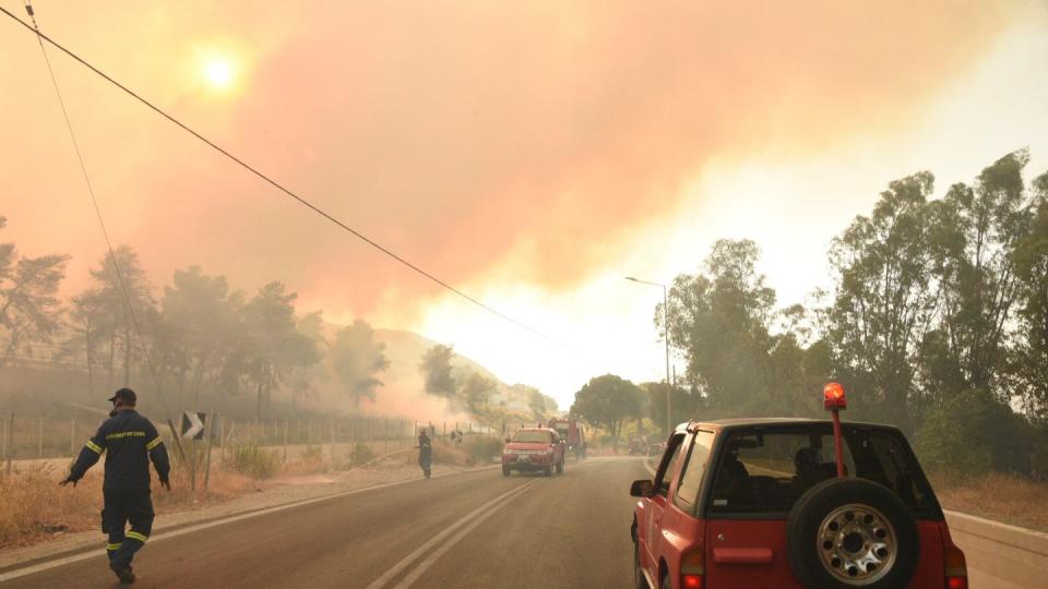 Feuerwehrleute bekämpfen einen Waldbrand in der Nähe des Dorfes Lampiri, westlich von Patras.