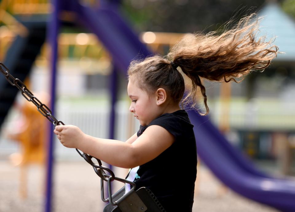 Addie Haywood, 4, of Canton flies high on the swings at North Park in Jackson Township.