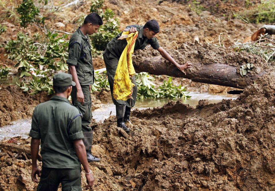 Members of a military rescue team conduct a search at the site of a landslide at the Koslanda tea plantation near Haldummulla