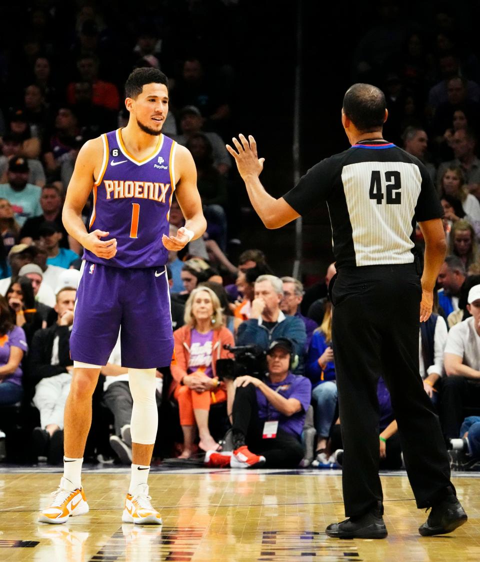 Phoenix Suns guard Devin Booker (1) reacts after being hit with a foul by referee Eric Lewis (42) against the Minnesota Timberwolves in the first half at Footprint Center in Phoenix on March 29, 2023.