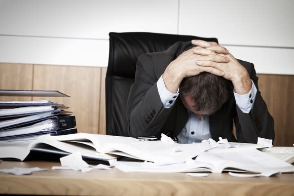 Man with head down at desk