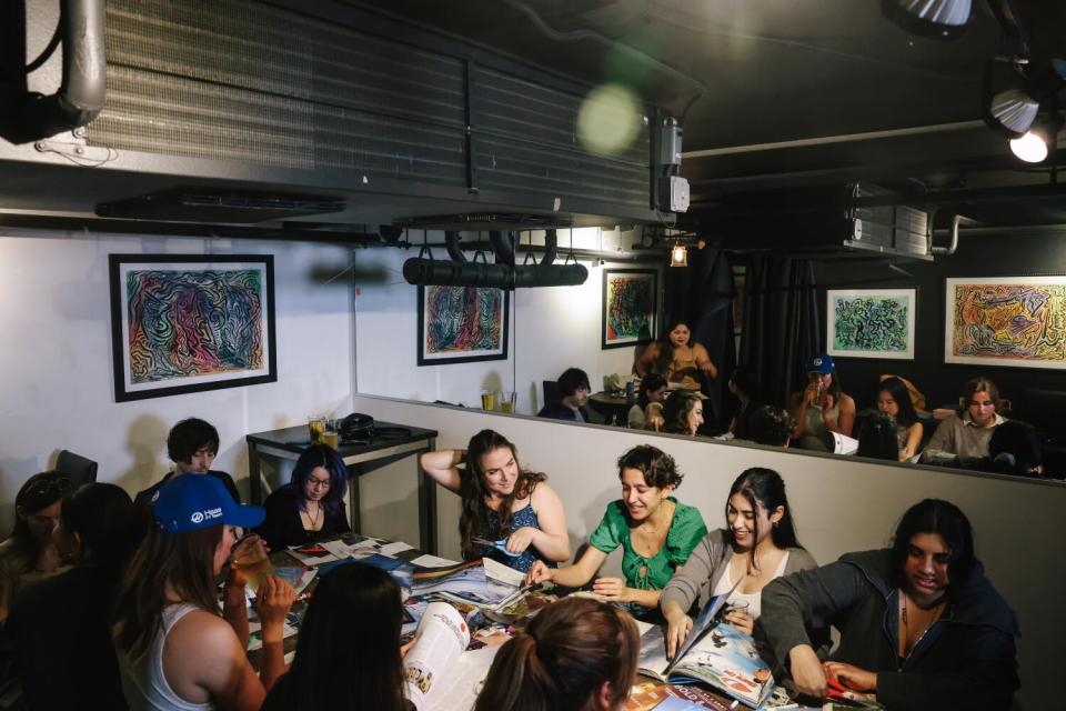 A long table filled with people on either side, a mirror behind reflecting them