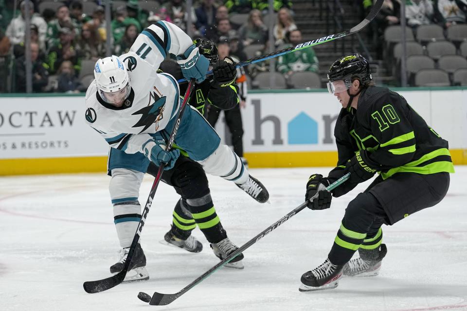 San Jose Sharks center Luke Kunin (11) works to gain control of the puck against Dallas Stars defenseman Esa Lindell, rear, and Ty Dellandrea (10) in the second period of an NHL hockey game in Dallas, Friday, Nov. 11, 2022. (AP Photo/Tony Gutierrez)