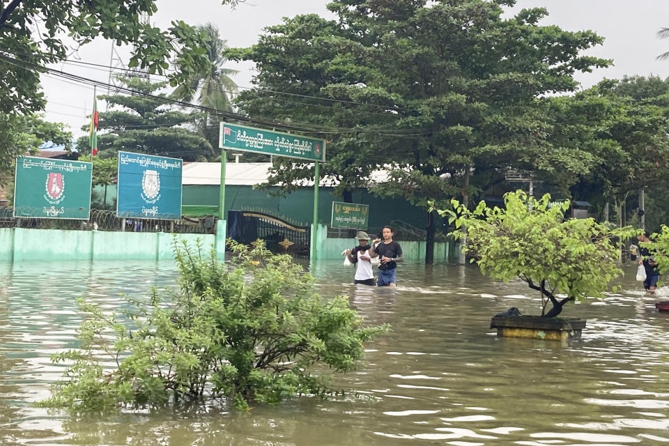 Local residents wade through a flooded road in Bago, about 80 kilometers (50 miles) northeast of Yangon, Myanmar, Monday, Oct.9, 2023. Flooding triggered by heavy monsoon rains in Myanmar’s southern areas has displaced more than 10,000 people and disrupted traffic on the rail lines that connect the country’s biggest cities, officials and state-run media said Monday. (AP Photo/Thein Zaw)