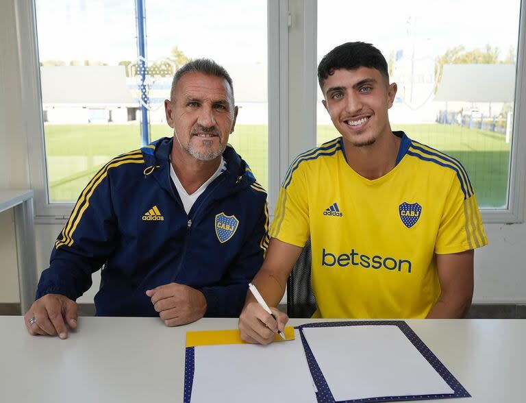 Mateo Mendia firma su primer contrato profesional en Boca; a su lado, Raúl Cascini, del Consejo de Fútbol