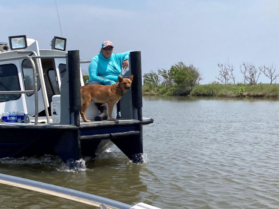 A volunteer and a dog trained to search for cadavers join others looking for survivors of the Seacor Power, a lift boat that capsized on April 13 off the Louisiana coast. Volunteers have been searching by air and boat for any sign of those still missing. (AP Photo/Rebecca Santana)