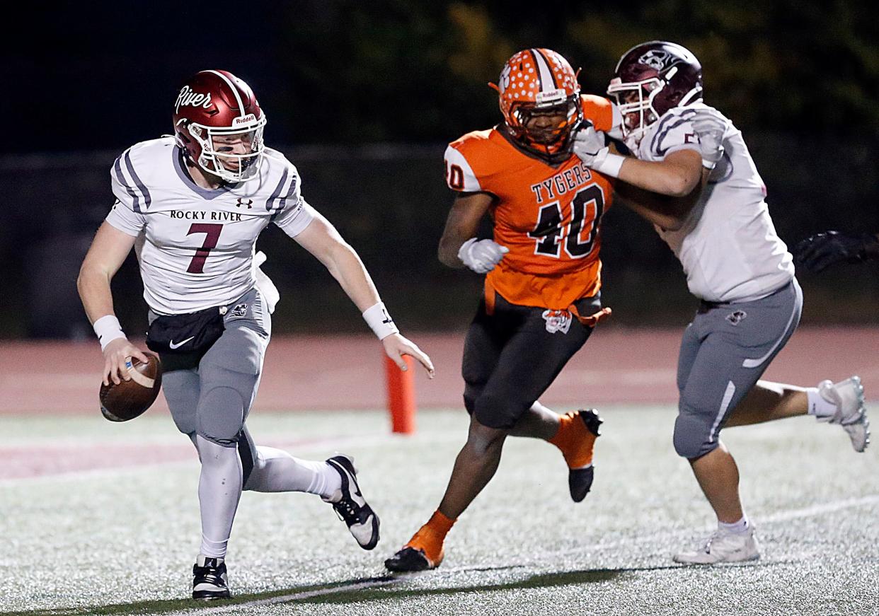 Mansfield Senior High School's Symirr Phillips (40) flushes Rocky River High School's Julian Patti (7) out of the pocket during their OHSAA Division III high Region 10 high school football quarterfinal game action Friday, Nov. 3, 2023 at Rocky River Stadium. TOM E. PUSKAR/MANSFIELD NEWS JOURNAL