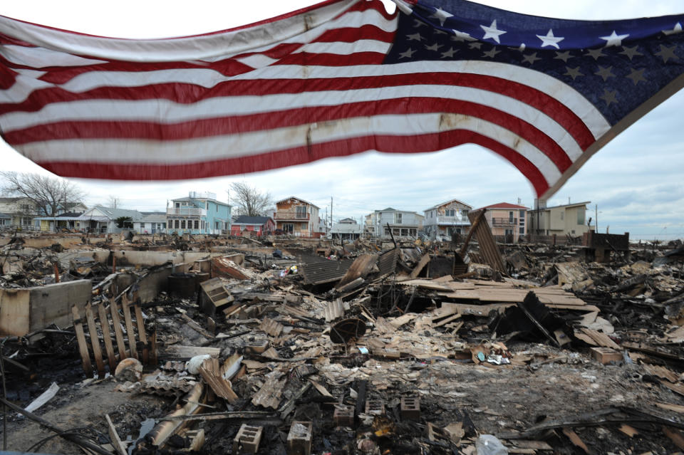 An American flag flies above a burned-out Breezy Point, Queens, in the aftermath of Hurricane Sandy. (Photo: David Handschuh/NY Daily News via Getty Images)