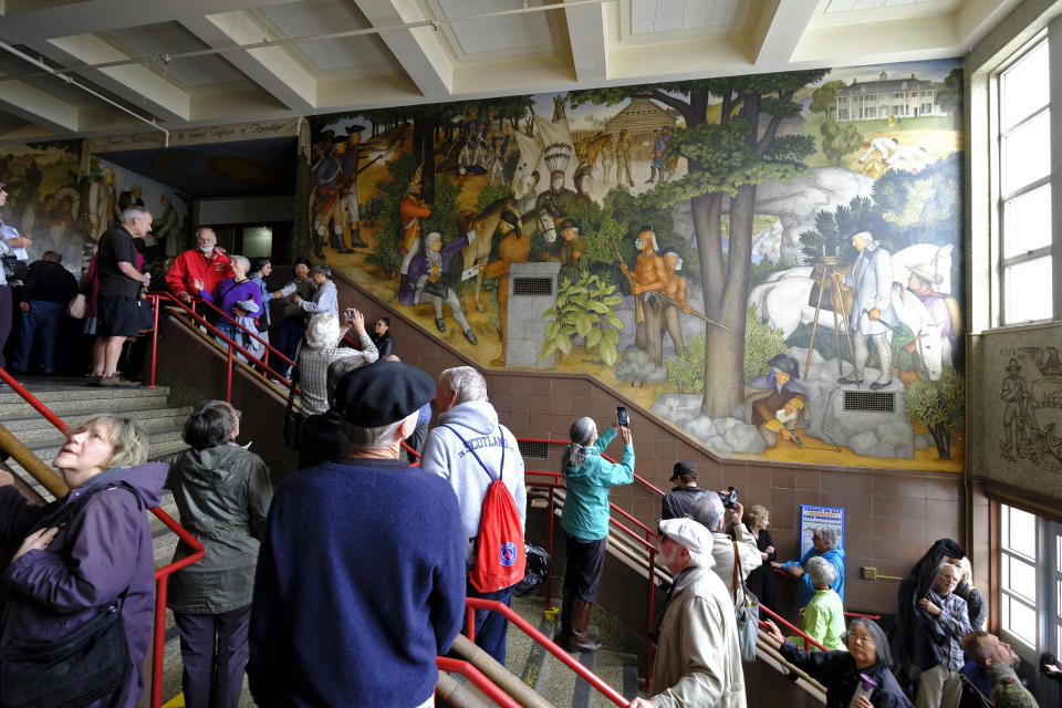 FILE - People fill the main entryway of George Washington High School to view the controversial 13-panel, 1,600-square foot mural, the "Life of Washington," during an open house for the public on Aug. 1, 2019, in San Francisco. The San Francisco school board voted Wednesday, June 22, 2022, to rescind a previous decision to cover up a George Washington campus mural from the 1930s that critics claim is racist and degrading in its depiction of Black and Native American people. (AP Photo/Eric Risberg, File)