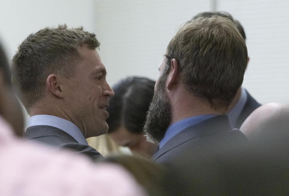 FILE - Defense attorney Casey Arbenz, left, smiles at his client, Matthew Collins, after he is declared not guilty in the killing of Manny Ellis, Dec. 21, 2023, in Pierce County Superior Court in Tacoma, Wash. Three Washington state police officers who were cleared of all criminal charges last month in the 2020 death of Ellis will each receive $500,000 to leave the Tacoma Police Department, according to documents released Tuesday, Jan. 16, 2024. (Ellen M. Banner/The Seattle Times via AP, Pool, File)
