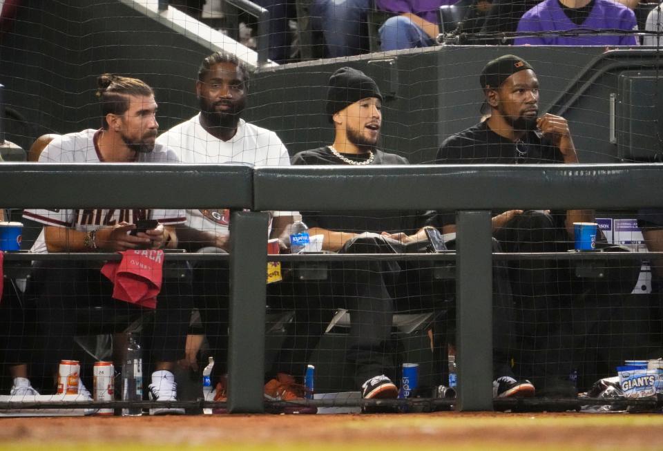 Michael Phelps (left) and Phoenix Suns players Devin Booker (second from right) and Kevin Durant (right) watch Game 5 of the NLCS of the 2023 MLB playoffs between the Arizona Diamondbacks and the Philadelphia Phillies at Chase Field on Oct. 21, 2023, in Phoenix, AZ. The Phillies beat the Diamondbacks 6-1, giving Philadelphia the overall lead of 3-2 in the NLCS playoffs.