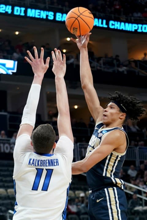 Akron’s Enrique Freeman shoots over Creighton’s Ryan Kalkbrenner during the first half of a college basketball game in the first round of the NCAA men’s tournament Thursday, March 21, 2024, in Pittsburgh. (AP Photo/Matt Freed)