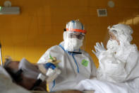 Healthcare workers attend to a COVID-19 patient in an intensive care unit (ICU) at Na Bulovce hospital in Prague, Czech Republic, Thursday, Oct. 1, 2020. A record surge of new coronavirus infections in the Czech Republic in September has been followed by a record surge of those hospitalized with COVID-19. The development has started to put the health system in the country under serious pressure for the first time since the pandemic hit Europe. (AP Photo/Petr David Josek)