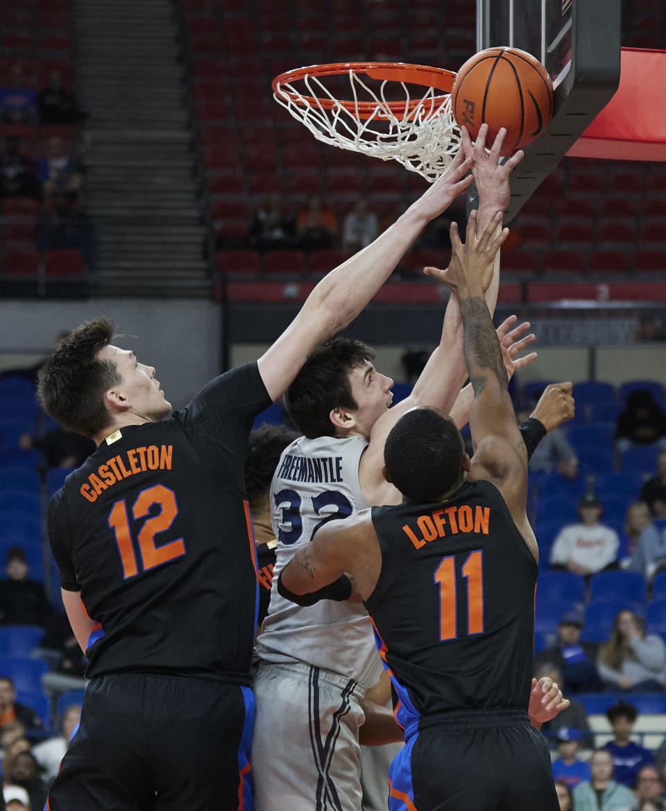 Xavier forward Zach Freemantle, center, has a shot blocked as Florida forward Colin Castleton, left, and guard Kyle Lofton defend during the first half of an NCAA college basketball game in the Phil Knight Legacy tournament in Portland, Ore., Thursday, Nov. 24, 2022. (AP Photo/Craig Mitchelldyer)
