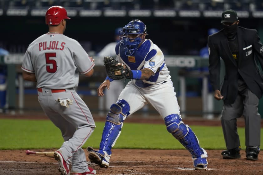 Kansas City Royals catcher Salvador Perez, right, forces out Los Angeles Angels Albert Pujols (5) during the sixth inning of a baseball game at Kauffman Stadium in Kansas City, Mo., Tuesday, April 13, 2021. (AP Photo/Orlin Wagner)