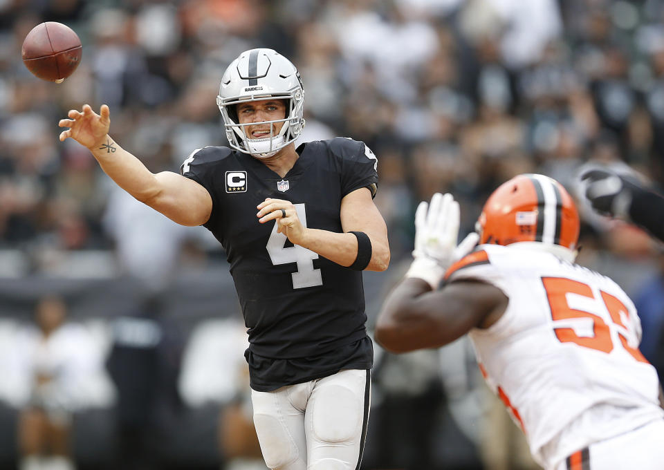 Oakland Raiders quarterback Derek Carr (4) passes against Cleveland Browns linebacker Genard Avery (55) during overtime of an NFL football game in Oakland, Calif., Sunday, Sept. 30, 2018. The Raiders won 45-42. (AP Photo/D. Ross Cameron)