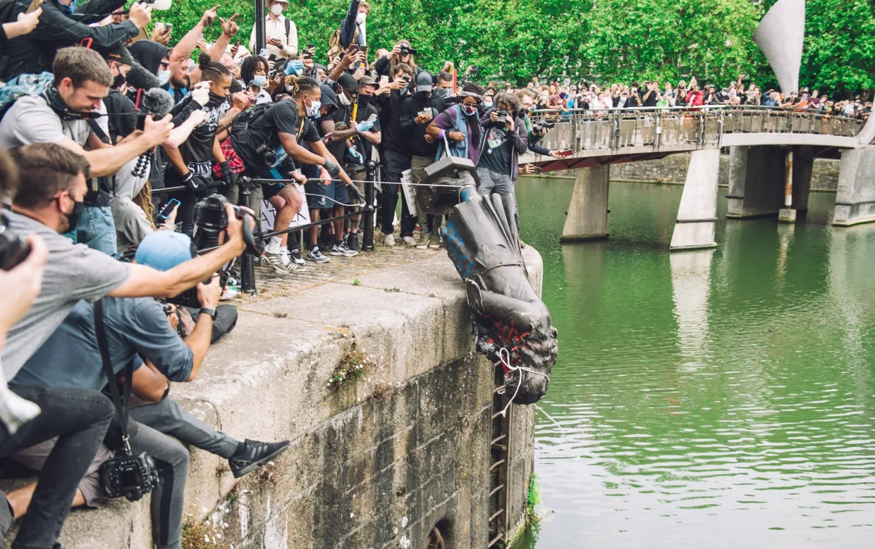 The statue of Colston is pushed into the river Avon