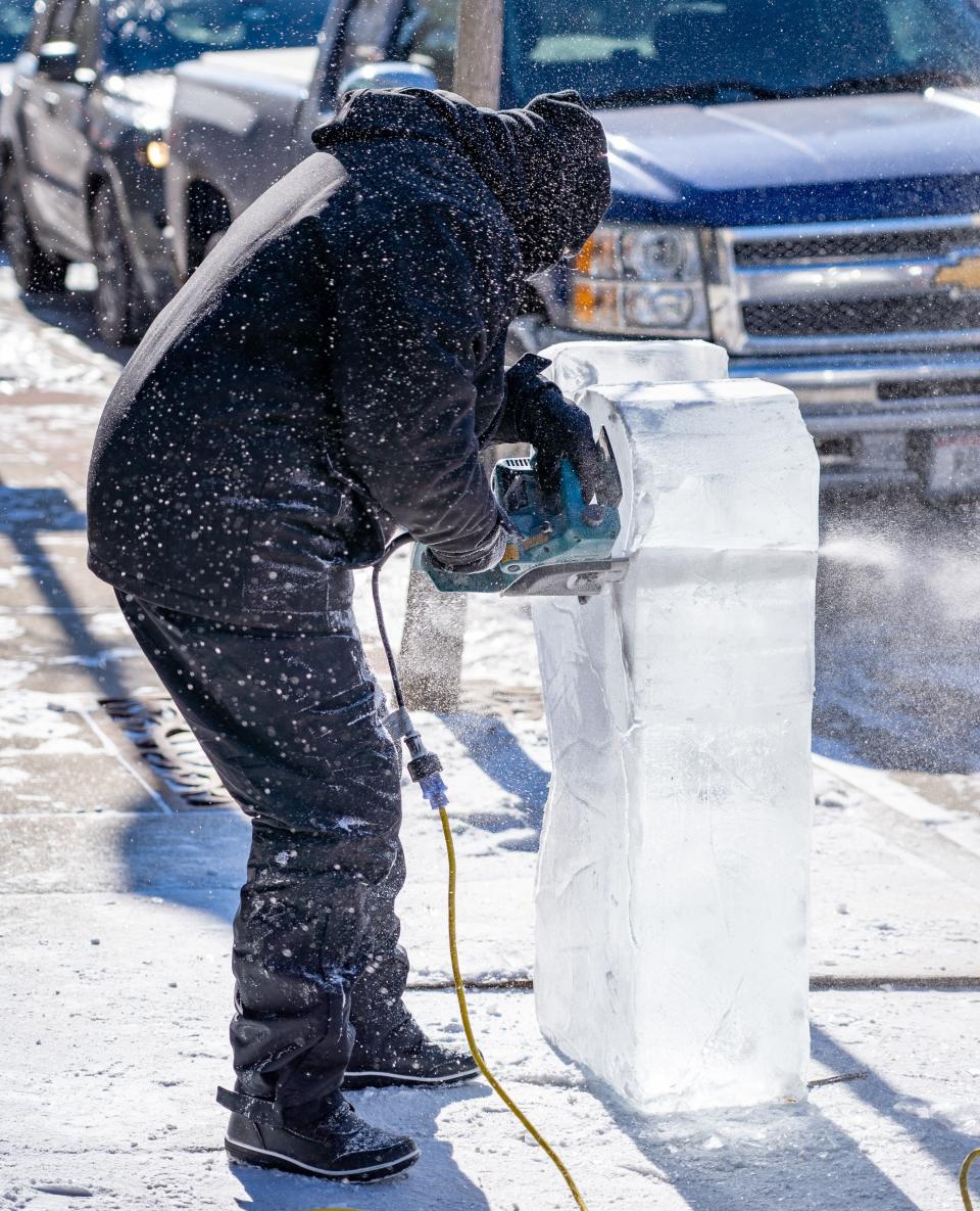 Ice chips fly as a carver works to turn a block of ice into a work of art at last year's Fire & Ice in Sturgeon Bay.