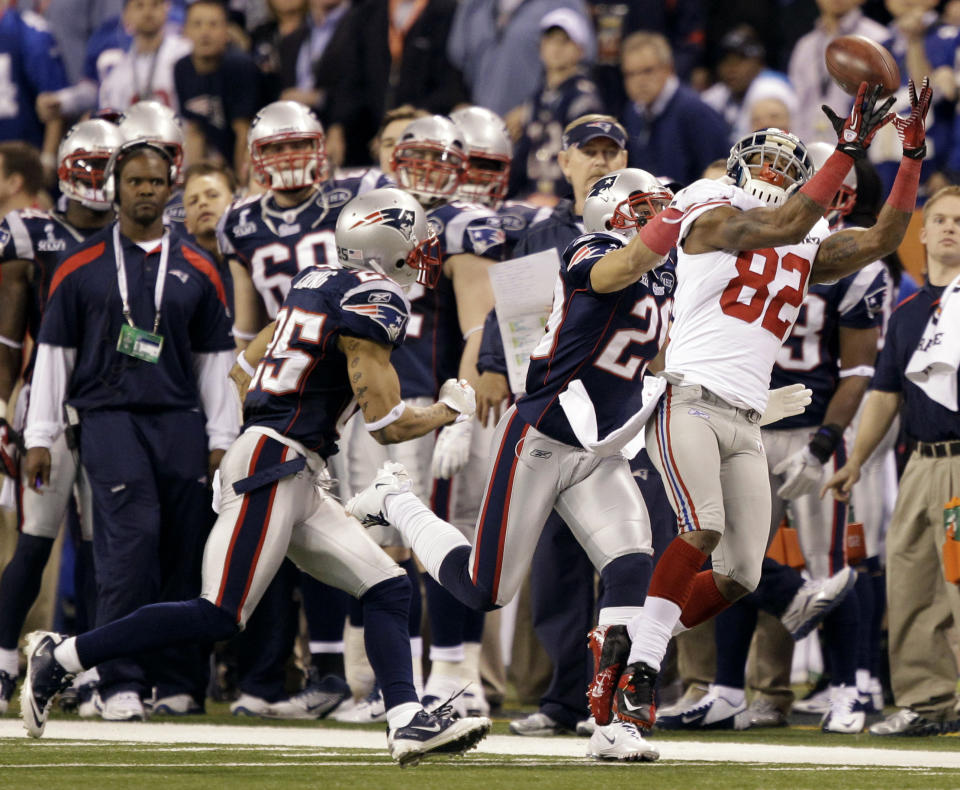 FILE - In this Feb. 5, 2012, file photo, New York Giants wide receiver Mario Manningham (82) catches a pass ahead of New England Patriots defensive back Sterling Moore, center, and safety Patrick Chung, left, during the second half of NFL Super Bowl XLVI football game in Indianapolis. The NFL revealed 70 of the 100 greatest plays in league history on Friday night with a TV special produced by NFL Films that has everything from spectacular offensive performances to defensive gems. In balloting conducted by The Associated Press, 68 media members on a nationwide panel voted for their top 100. Among those disclosed is Manningham’s clutch reception to spark the Giants’ comeback to defeat the Patriots. (AP Photo/Marcio Jose Sanchez, File)