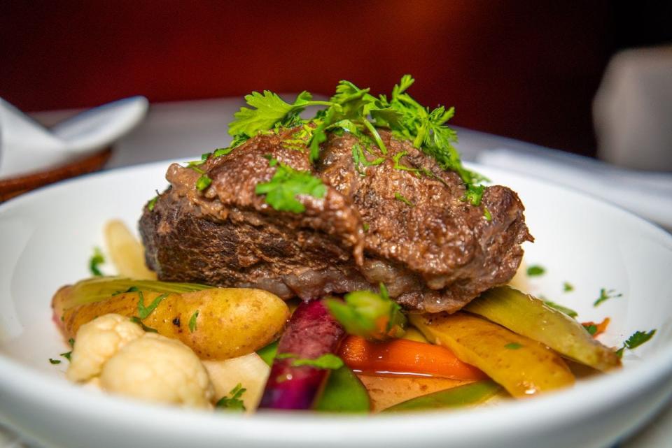 Braised beef cheeks with steamed summer vegetables and a coriander vinaigrette is on the Bastille Day menu at La Goulue Palm Beach.