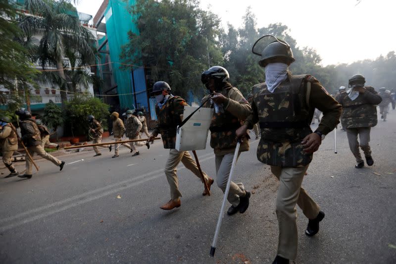 Police chase away demonstrators during a protest against a new citizenship law, in New Delhi