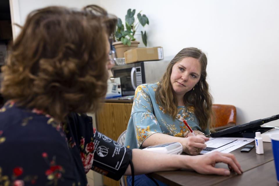 Camilla Hancock takes a blood pressure reading from a patient for a medical study at Basin Pharmacy in Basin, Wyo., on Wednesday, Feb. 21, 2024. (AP Photo/Mike Clark)