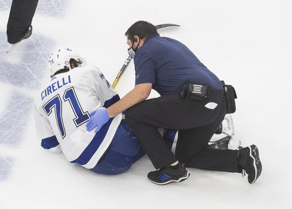 Tampa Bay Lightning center Anthony Cirelli (71) speaks with the team's trainer after getting injured against the New York Islanders during the second period of Game 6 of the NHL hockey Eastern Conference final, Thursday, Sept. 17, 2020, in Edmonton, Alberta. (Jason Franson/The Canadian Press via AP)