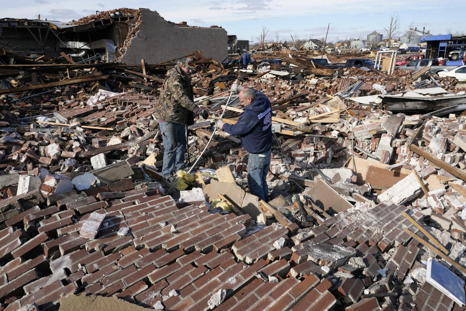 Men sort through a destroyed business Saturday, Dec. 11, 2021, in Mayfield, Ky. Tornadoes and severe weather caused catastrophic damage across several states Friday, killing multiple people overnight. (AP Photo/Mark Humphrey)