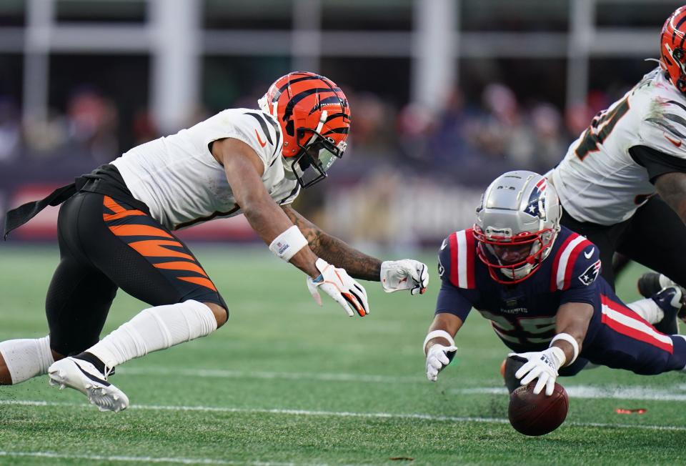 Patriots cornerback Marcus Jones, right, jumps on a fumble by  Bengals wide receiver Ja'Marr Chase in the fourth quarter.