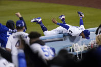 Los Angeles Dodgers right fielder Mookie Betts hangs on the wall as fans cheer after making a catch on a ball hit by Arizona Diamondbacks' Tim Locastro during the seventh inning of a baseball game Monday, May 17, 2021, in Los Angeles. (AP Photo/Mark J. Terrill)