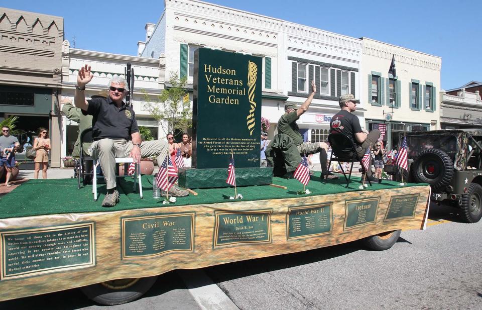 Military veterans ride on the Hudson Veterans Memorial Garden float during the 2022 Hudson Memorial Day Parade.