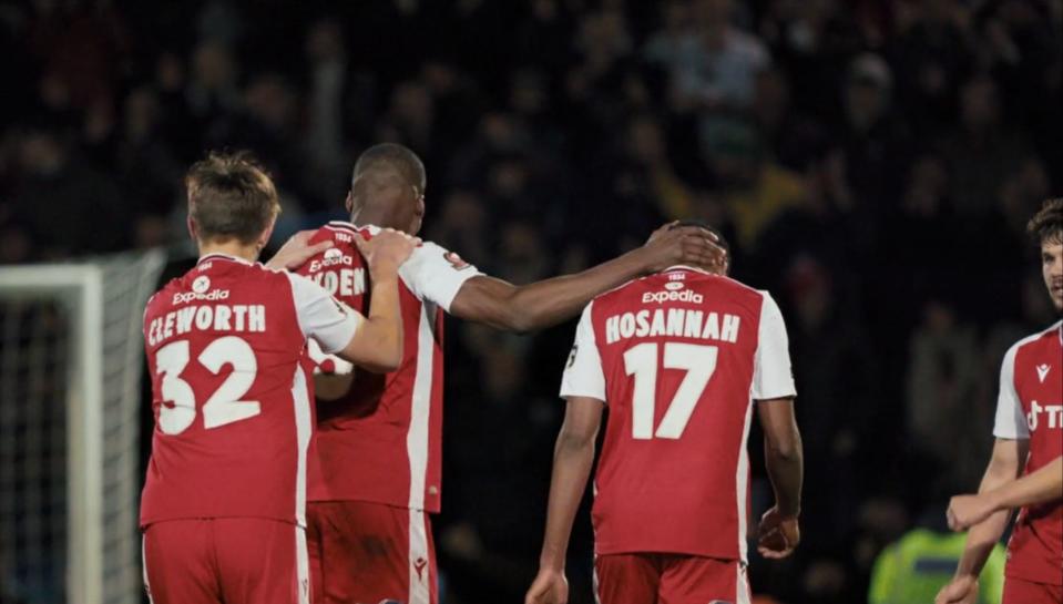 Wrexham players celebrating on the pitch after a win