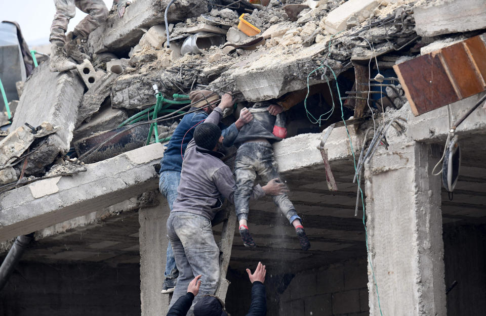 Residents retrieve an injured girl from the rubble of a collapsed building following an earthquake in the town of Jandaris, in the countryside of Syria's northwestern city of Afrin.<span class="copyright">Rami Al Sayed—AFP/Getty Images</span>