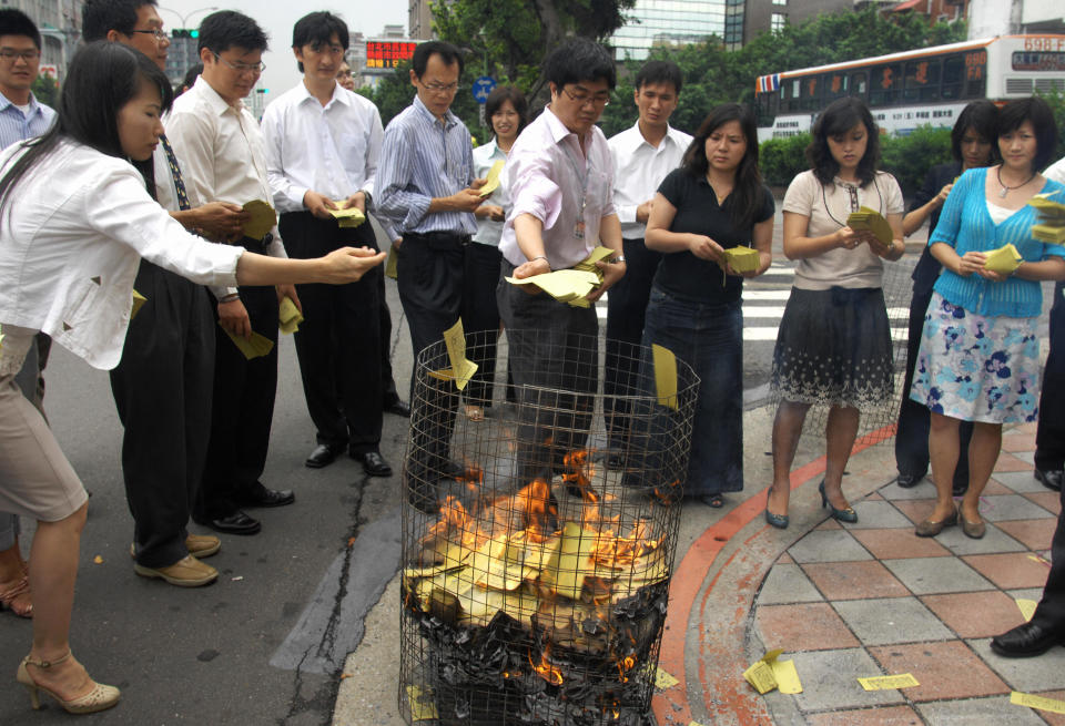TO GO WITH STORY BY AMBER WANG 'TAIWAN-ENVIRONMENT-RELIGION'  In this photograph taken on August 11, 2008 a group of office workers burn ritual paper money outside their office in Taipei as offerings to appease the spirits during the 