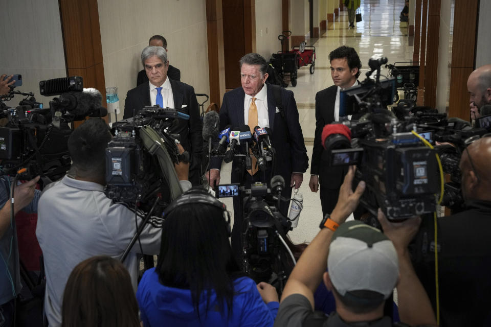 Dan Cogdell, rear center, a defense attorney for Texas Attorney General Ken Paxton, talks to reporters with fellow defense attorneys Philip Hilder, rear left, and Anthony Osso, Jr., rear right, after Paxton appeared in the 185th District Court for a hearing in his securities fraud case, Friday, Feb. 16, 2024, at the Harris County criminal courthouse in Houston. A judge on Friday rejected Paxton’s attempts to throw out felony securities fraud charges that have shadowed the Republican for nearly a decade. (Jon Shapley/Houston Chronicle via AP)