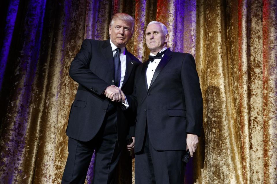 President-elect Donald Trump, left, stands with Vice President-elect Mike Pence during the presidential inaugural Chairman's Global Dinner, Tuesday, Jan. 17, 2017, in Washington. (AP Photo/Evan Vucci)