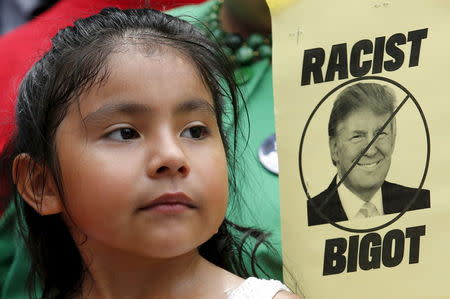 A girl participates in a protest calling for businesses to sever their relationships with U.S. Republican presidential candidate Donald Trump over his recent comments about Mexican immigrants as they demonstrate outside the site of a new hotel owned by Trump at the Old Post Office Building in Washington July 9, 2015. REUTERS/Yuri Gripas