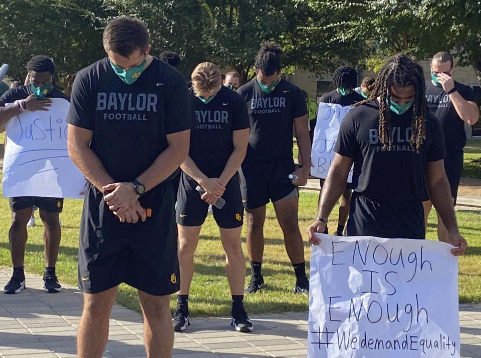 Members of the Baylor football team bow their heads during a prayer after marching around campus, Thursday, Aug. 27, 2020, in Waco, Texas, protesting the shooting of Jacob Blake in Wisconsin. (Rod Aydelotte/Waco Tribune-Herald via AP)