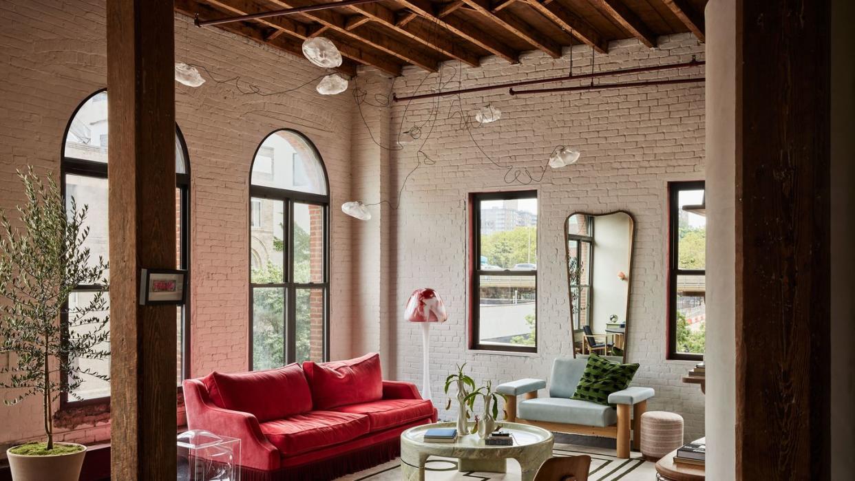 a living room with a red couch and a table
