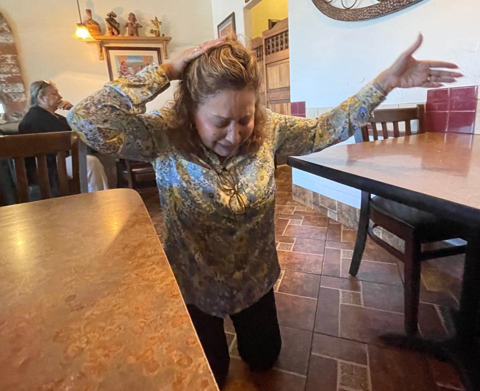 La Casita Cafe co-owner Delores “Lola” Compean demonstrates how she knelt before her dying uncle, Frank, who laid hands on her head and prayed a blessing and business success.