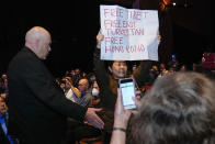 A protester holds up a placard during a speech by China's Ambassador to Australia, Xiao Qian on the state of relations between Australia and China at the University of Technology in Sydney, Australia, Friday, June 24, 2022.(AP Photo/Mark Baker)