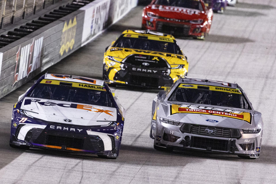 Denny Hamlin (11) leads Chase Briscoe (14) and Christopher Bell (20) during a NASCAR Cup Series auto race, Saturday, Sept. 21, 2024, in Bristol, Tenn. (AP Photo/Wade Payne)