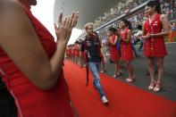 Grid girls clap as Red Bull Formula One driver Sebastian Vettel of Germany walks on a red carpet during the Indian F1 Grand Prix at the Buddh International Circuit in Greater Noida, on the outskirts of New Delhi, October 27, 2013. REUTERS/Ahmad Masood (INDIA - Tags: SPORT MOTORSPORT F1)