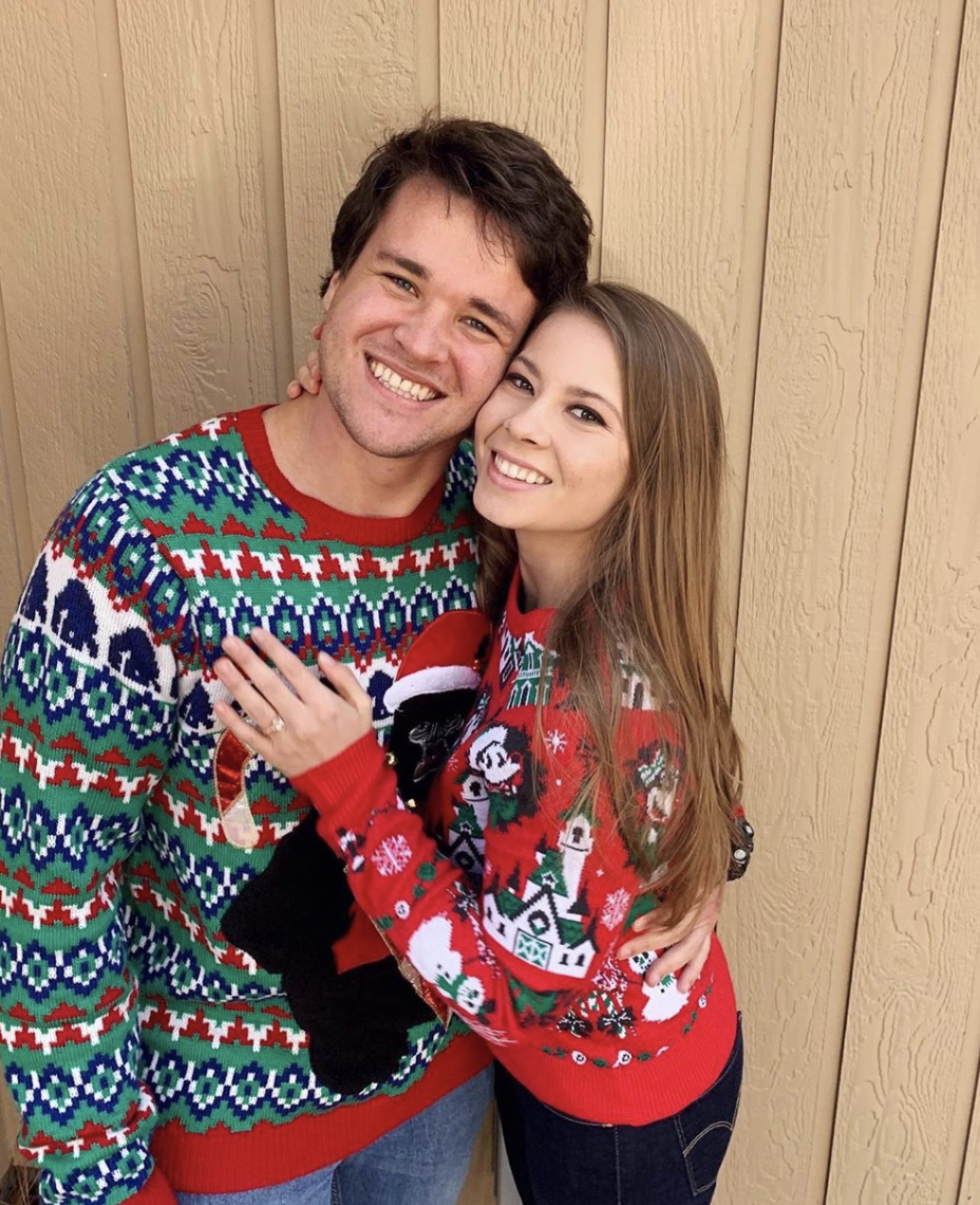 Bindi Irwin and Chandler Powell wearing Christmas-themed jumpers.