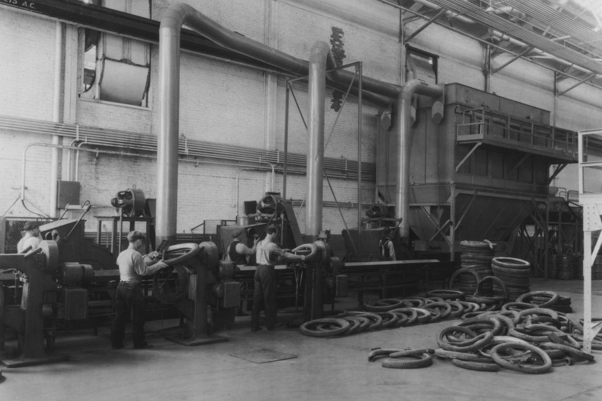 workers preparing motor car tyres on a production line in a factory, usa, circa 1925