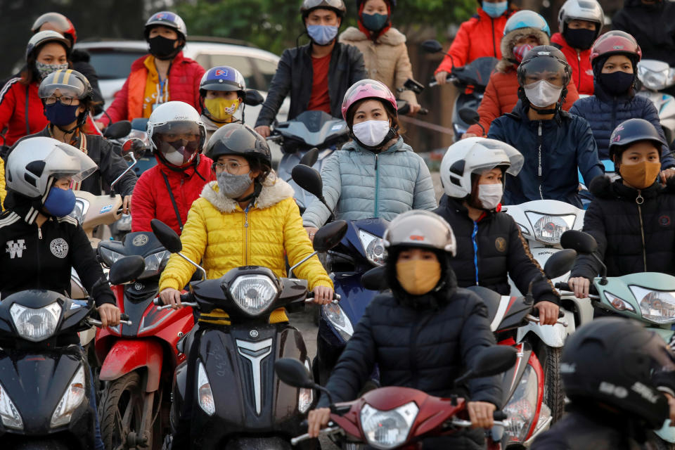 Labourers wearing protective masks gather while they wait for a ferry on the way home after work, despite a government rule on social distancing during the coronavirus disease (COVID-19) outbreak in Hai Duong province, Vietnam April 7, 2020. REUTERS/Kham     TPX IMAGES OF THE DAY